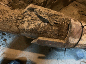 The main drain pipe, discovered during demolition, held together with wood blocks and zip ties
